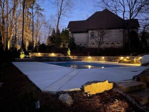 Pool deck and retaining wall with landscape lighting at night