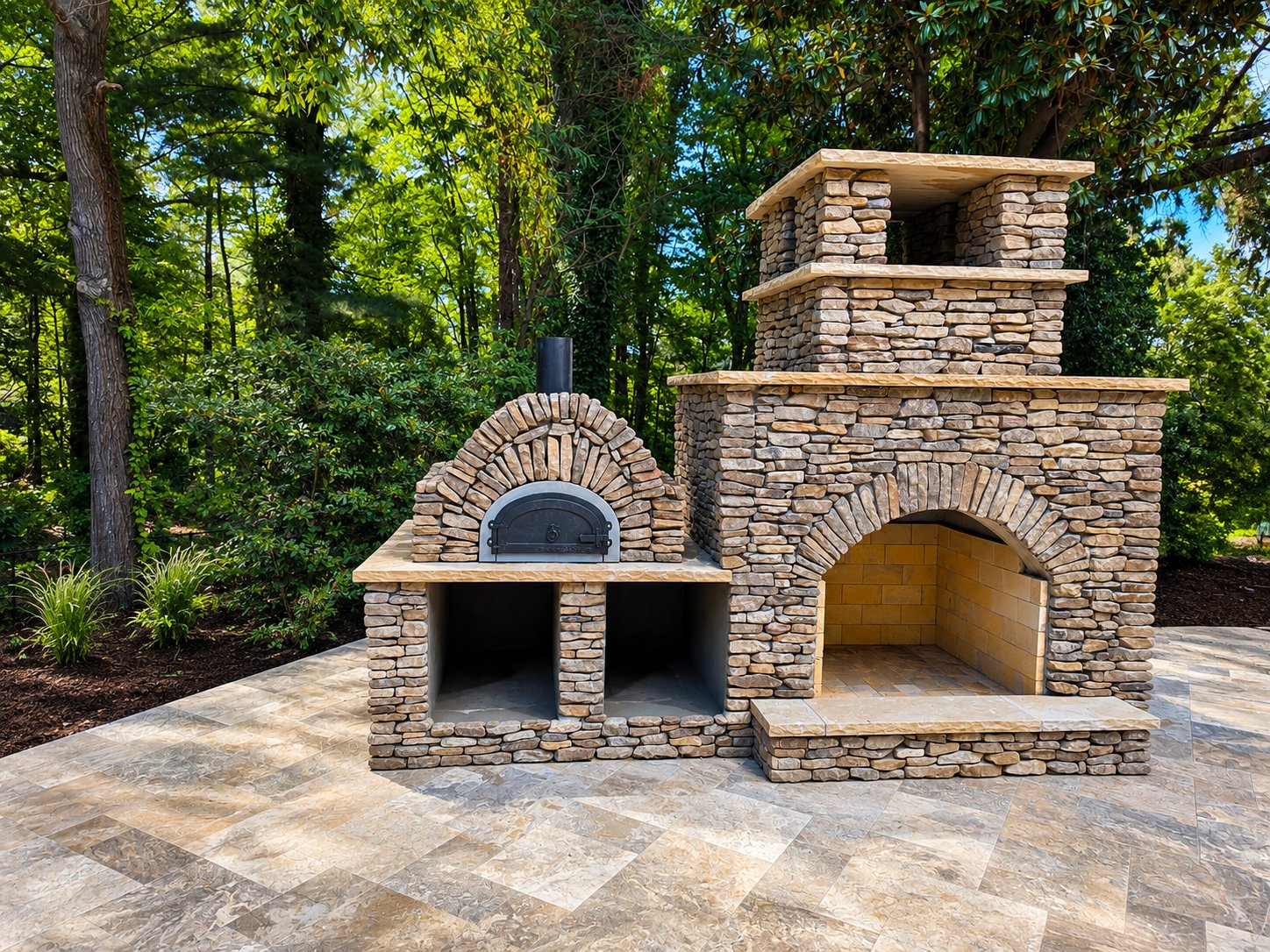 Custom stacked stone outdoor fireplace with built-in pizza oven on a stone patio